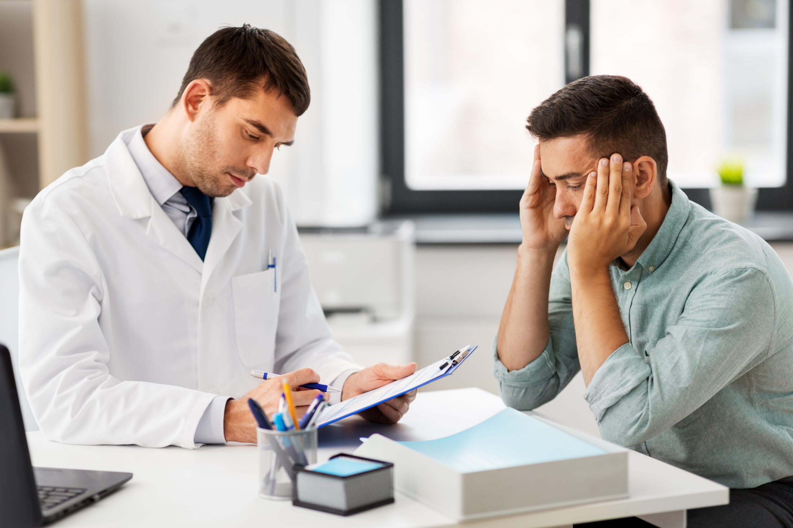 doctor with clipboard and male patient at hospital how does cbt therapy work | Group Therapy Services in Beverly Hills, CA | COPE Psychological Center